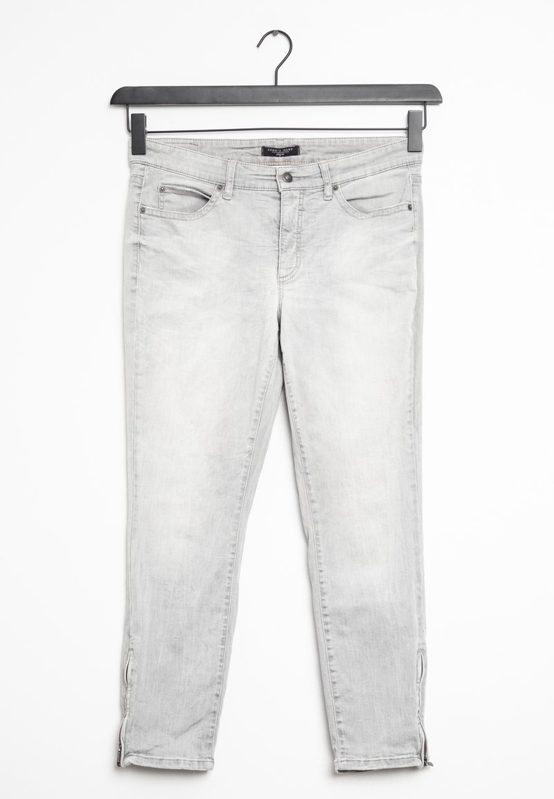 Jean gris clair coupe slim avec poches avant et bas de jambes zippés suspendu à un cintre noir sur fond blanc.