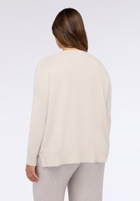 Hellbeiger übergroßer Pullover mit geripptem Saum und Bündchen, aus weichem Material, mit einfachem, nahtlosem Design.