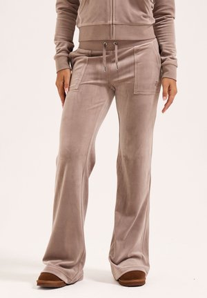 Samt-Jogginghosen in hellem Taupe mit entspannter Passform, ausgestattet mit Seitentaschen und verstellbaren Kordeln an der Taille. Glatte Textur.