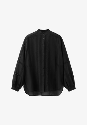 Blouse noire à manches longues boutonnée avec col mandarin, rayures verticales en dentelle et tissu légèrement transparent.