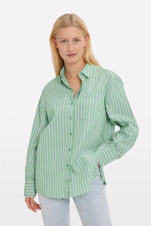 Green striped button-up shirt with long sleeves, a relaxed fit, and a breast pocket. Vertical white stripes contrast against the green fabric.