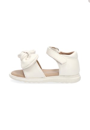 Sandalia blanca para niño pequeño con suela acolchada, correa en el tobillo y detalle de lazo en la parte delantera.