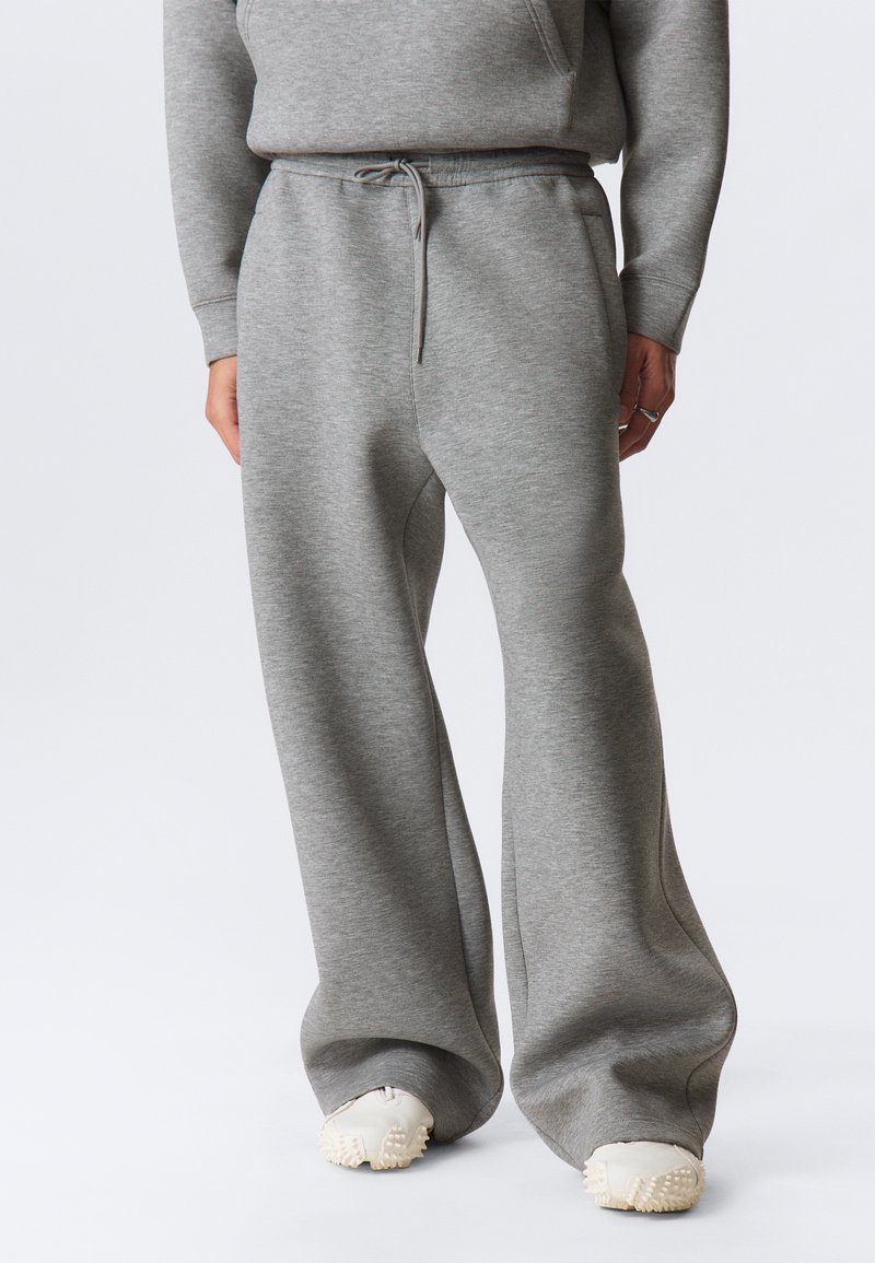 Light gray wide-leg sweatpants made from soft fabric with an elastic waistband, drawstring detail, and side pockets.