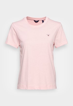 T-shirt en coton rose clair à manches courtes, col rond, avec un petit logo brodé sur la poitrine. Texture douce et coupe décontractée.