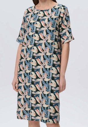 Femme portant une robe longueur genou avec des manches longueur coude présentant un motif abstrait de feuilles en bleu, beige et corail.