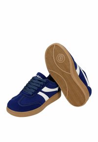 Paire de baskets bleues avec des bandes latérales blanches et des semelles en gomme, une chaussure montrant le dessus et l'autre montrant le dessin de la semelle en dessous.