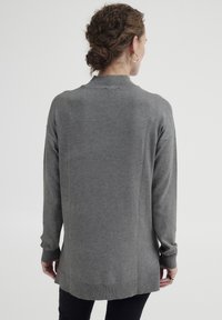 Grauer Strickpullover mit langen Ärmeln, gerippten Bündchen und lockerer Passform. Verfügt über einen runden Halsausschnitt und einen längeren hinteren Saum für zusätzlichen Schutz.