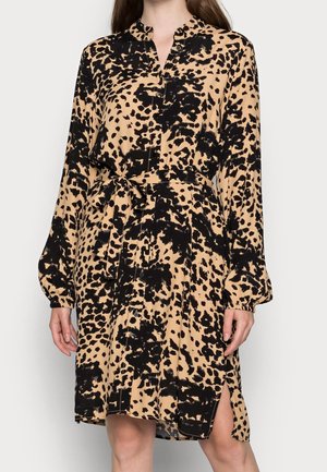 Abito camicia con stampa leopardata in tonalità tan e nera, con maniche lunghe, botoe di chiusura, cintura annodabile in vita e spacco laterale per una maggiore libertà di movimento. Tessuto morbido.