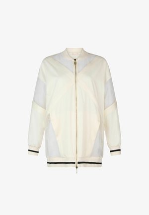 Giacca bomber crema con pannelli trasparenti, strisce nere a contrasto sui polsini e sull'orlo, chiusura frontale con zip e colletto rialzato.
