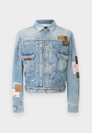 Veste en jean bleu clair avec fermeture à boutons, deux poches poitrine et éclaboussures de peinture multicolores ainsi que des patchs en tissu sur les manches et le devant.