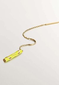 Collar de cadena de oro con un colgante en forma de bambú de color verde lima que presenta acentos de hoja dorada, exhibido sobre un fondo claro y liso.