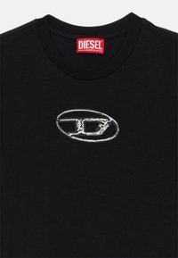 T-shirt en coton noir avec un col rond, arborant un logo argenté sur le devant. Texture lisse, design simple, manches courtes.