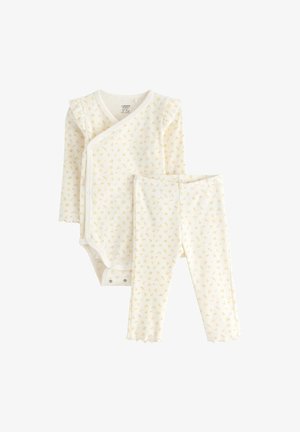 Robe pour nourrisson blanche comprenant un bodysuit à manches longues avec un motif floral jaune et un legging assorti. Bordures volantes et boutons-pression inclus.