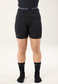 Black athletic shorts with a tight fit, featuring a textured waistband with "SWEDEMOUNT" logo and smooth fabric. Worn with black ribbed socks.