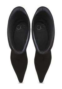 Zapatos de ante negro con puntera afilada, con una textura suave y un detalle mínimo. El interior presenta un forro suave con el logotipo grabado.