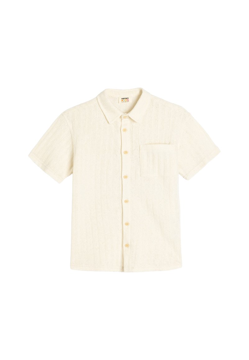 Korte mouwen witte blouse met een gestructureerd patroon, knoopsluiting aan de voorkant, kraag en een enkele borstzak. De knopen zijn lichtbruin.