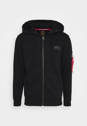 Sorte zip-up hoodie lavet af blødt stof, med en frontlomme, snor i hætten og en rød detalje på venstre ærme med en lynlås.