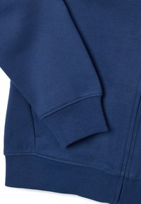 Sudadera azul marino con puños y dobladillo acanalados, presenta una textura suave y bolsillos laterales, diseñada para la comodidad y el calor.