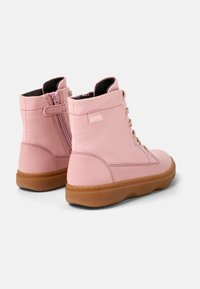 Stivali alla caviglia in pelle rosa con punta arrotondata, accessori in oro e zip laterale. Presentano una suola in gomma testurizzata e un collo imbottito.