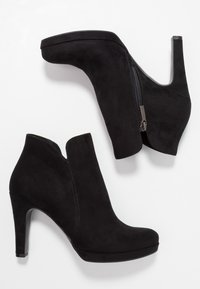 Schwarze Wildleder-Stiefeletten mit einem geschwungenen, hohen Absatz und einem seitlichen Reißverschluss. Sie verfügen über ein offenes Oberdesign und eine glatte Textur.