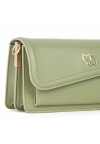 Grøn falsk læderpung med flaplukning, guldfarvet hardware og et geometrisk logo-tilbehør. Glat tekstur og syede kanter. Kompakt design.