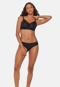 Soutien-gorge noir sans couture avec un décolleté en V, des bretelles ajustables et une culotte taille basse assortie. Texture lisse, design minimal et ceinture élastique.