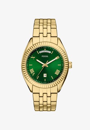 Montre en métal doré avec un cadran vert, des index en chiffres romains et un affichage de la date. Elle possède un bracelet à maillons et une lunette texturée.