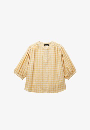 Blouse à carreaux jaunes et blancs avec manches bouffantes aux 3/4, encolure ronde et fermeture à boutons sur le devant.