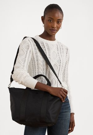 Black tote bag with dual handles and an adjustable shoulder strap. Made of durable material with a smooth texture and minimalistic design.