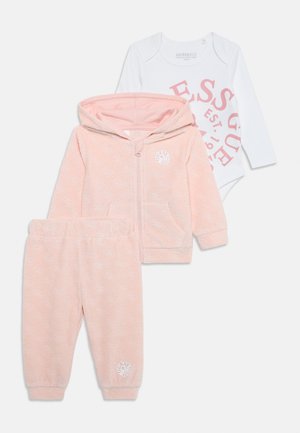 Completo per neonati in tre pezzi di colore rosa, composto da una felpa con zip, pantaloni abbinati e un body bianco con testo rosa. Tessuto morbido con dettagli del logo.