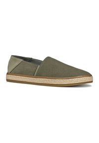 Zapatos slip-on de tela verde con una suela intermedia de yute y una suela exterior de goma; cuentan con una punta redonda y paneles laterales en contraste.