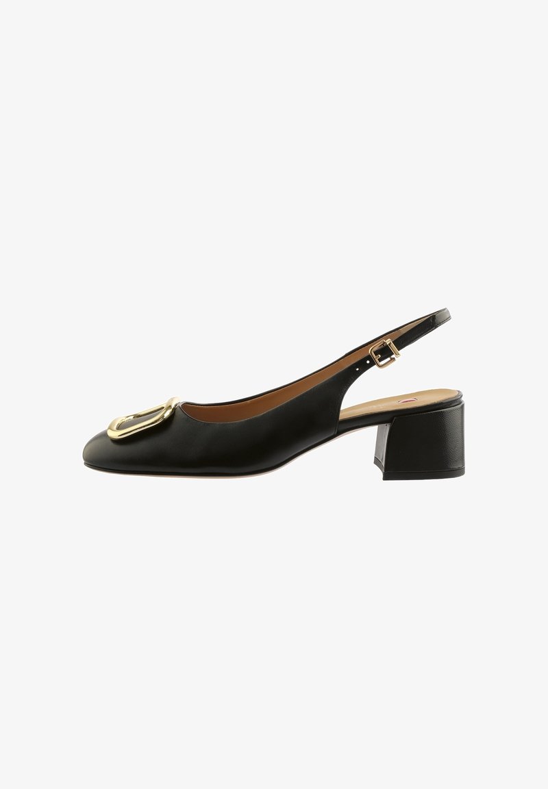 Chaussure slingback en cuir noir avec petit talon bloc et grande boucle dorée à l'avant.