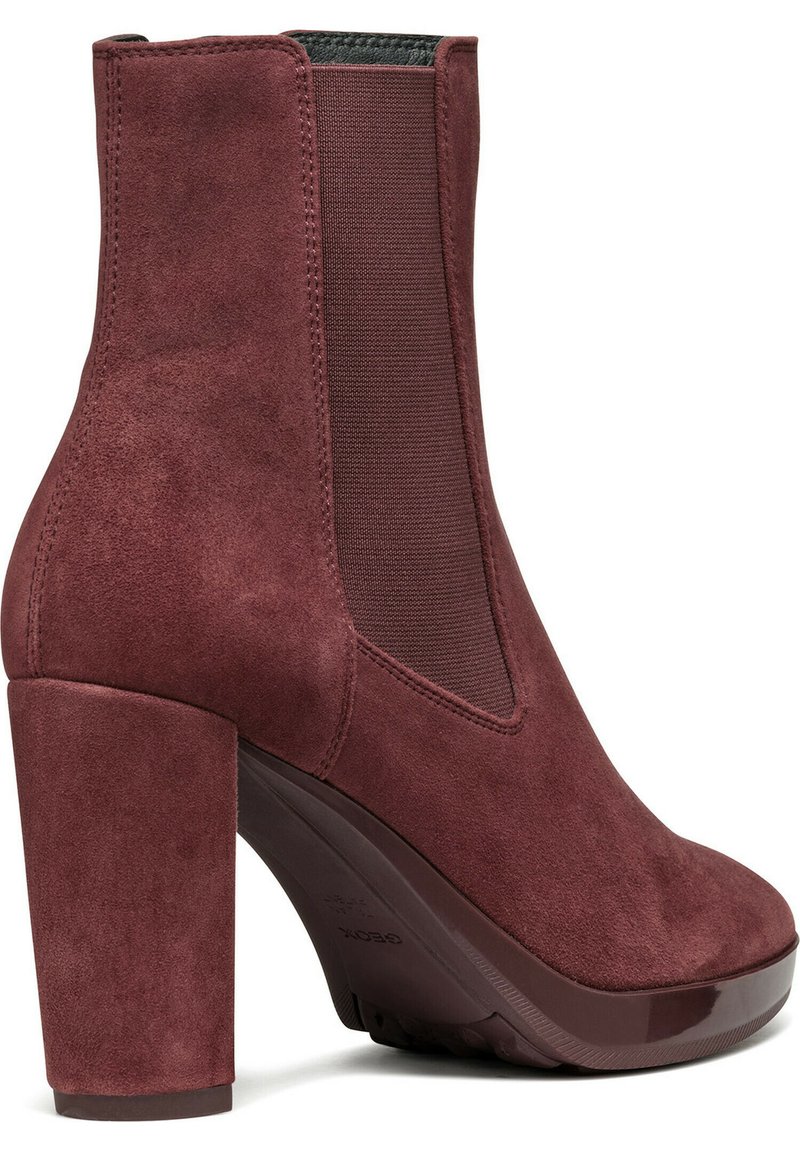 Bordeaux suede enkellaarsje met een hoge blokhak, elastische zijkanten en een glad afgeronde neus. Accentuatie met een glanzende zool.