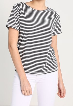 T-shirt gris et blanc à rayures avec des manches courtes, un col rond, une coupe décontractée et des coutures d'ourlet visibles. Porté avec un pantalon blanc.