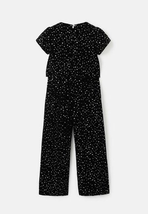 Salopetă neagră cu mâneci scurte, având un model cu puncte albe răspândite. Material moale, croi lejer și talie elastică pentru confort.