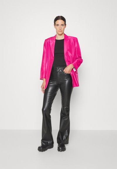 Fuchsia satin blazer with notched lapels over a black fitted top, paired with high-waisted black faux leather flared pants and black footwear.