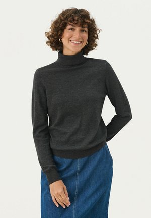 Un pull col roulé gris foncé en tissu doux, muni de manches longues et d'un ourlet côtelé, associé à une jupe en denim bleu.