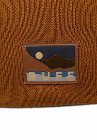 Brown knitted hat featuring a rectangular patch with mountain and river design, embroidered "BUFF," and a moon in a dark blue sky.