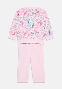 Sweatshirt thématique dinosaure rose à manches longues et pantalon rose assorti. Présente des graphismes de dinosaures colorés et des motifs de texte ludiques.