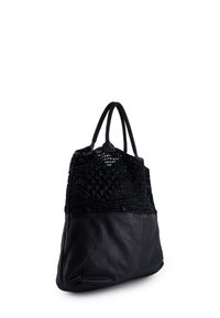 Černá taška na rameno s tkanou horní částí a hladkým koženým spodním dílem. Obsahuje dvě rukojeti a strukturovaný geometrický vzor.