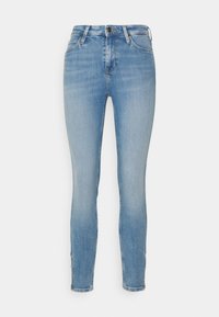 Jeans ajustados en denim azul claro, con una cintura alta, diseño de cinco bolsillos y un ligero desgaste. Bajo entallado con detalles de costura.