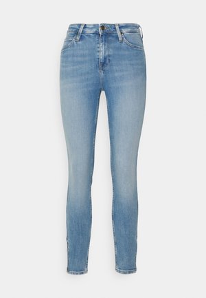 Jeans ajustados en denim azul claro, con una cintura alta, diseño de cinco bolsillos y un ligero desgaste. Bajo entallado con detalles de costura.