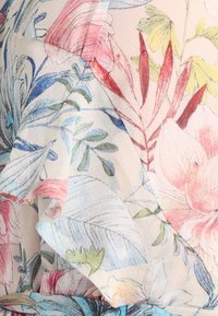 Il tessuto a stampa floreale presenta morbidi colori pastello, tra cui rosa, blu e verde. Il design include bordi arricciati e una texture leggera e liscia.
