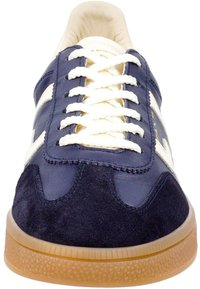 Sneaker blu navy con tomaia in pelle e camoscio, lacci bianco sporco e suola in gomma. Presenta un design semplice con accenti testurizzati.