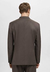 Braunes kariertes Sakko mit strukturiertem Design, Revers mit Kerbkragen und langen Ärmeln, das eine glatte Textur und eine maßgeschneiderte Passform zeigt.