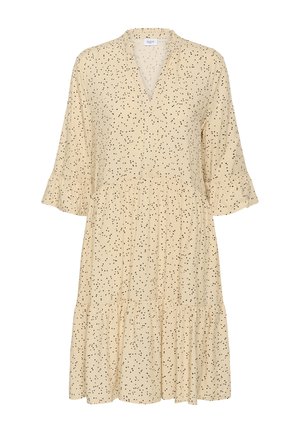 Robe crème en tissu léger, avec un col en V, des manches trois-quarts, des poignets volantés et un motif noir tacheté. Ourlet évasé.