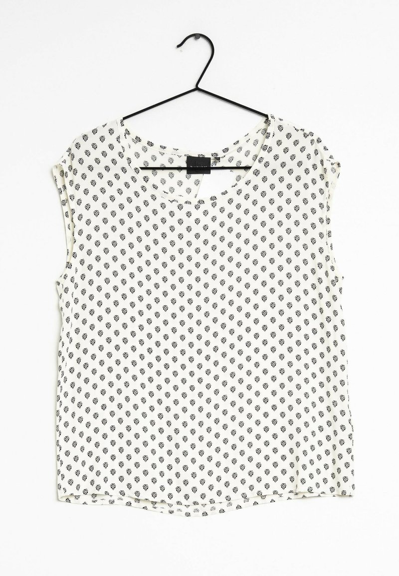 Camicia a maniche corte con scollatura tonda, realizzata in tessuto leggero, con sfondo bianco e piccoli motivi geometrici neri.