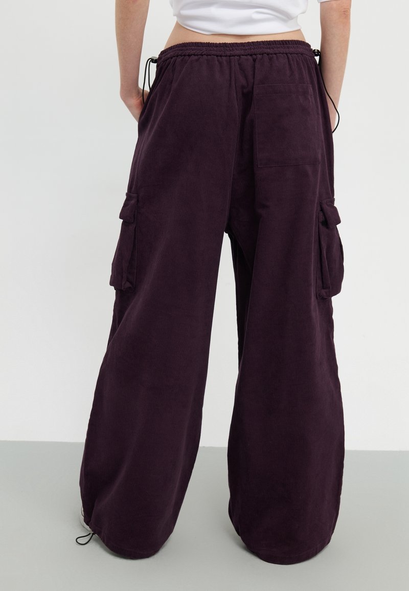 Baggy cordflanellbyxor i djup lila med en mjuk textur, med sidofickor och resårmidja med justerbara dragsko.