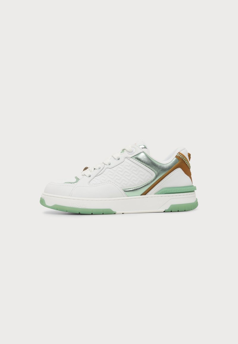 Λευκό sneaker χαμηλού σχεδίου με πράσινες λεπτομέρειες στη σόλα, μεταλλικές πράσινες λεπτομέρειες, ανάγλυφο σχέδιο στην πλευρά και καφέ περιμετρικό στο τακούνι.