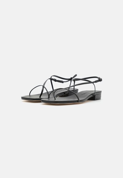 Mustat tasapohjaiset sandaalit, joissa on ohuet hihnat, minimalistinen muotoilu ja neliön muotoinen kärki. Valmistettu sileästä nahasta ja matalasta lohkokannasta.